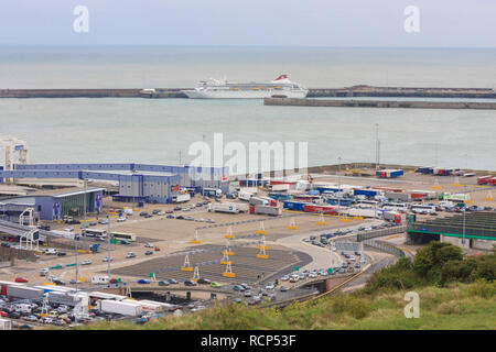 Camions et voitures en attente dans les lignes à bord d'un Cross Channel ferry dans le Port de Douvres. Le navire de croisière le Braemar est aussi vu dans le port. Angleterre, Royaume-Uni Banque D'Images