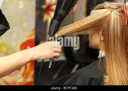 Cheveux teinture coiffure professionnel de son client dans le salon. Haircutter cheveux secs avec sèche-cheveux. Focus sélectif. Banque D'Images