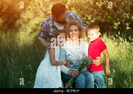 Jeune femme en fauteuil roulant avec sa famille. Portrait de famille Banque D'Images