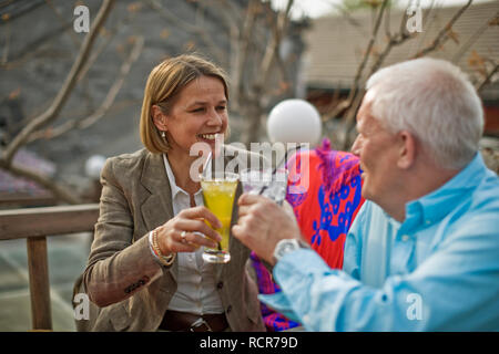 Happy senior couple toasting tandis que leur boisson. Banque D'Images