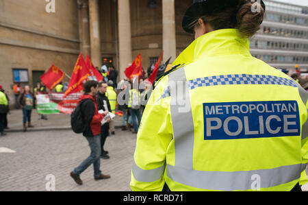 Metropolitan Police signe sur le dos d'une veste haute visibilité portés par des agents de police escortent une manifestation de rue à travers le centre de Londres, au Royaume-Uni. Banque D'Images