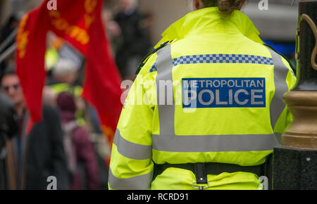 Metropolitan Police signe sur le dos d'une veste haute visibilité portés par des agents de police escortent une manifestation de rue à travers le centre de Londres, au Royaume-Uni. Banque D'Images