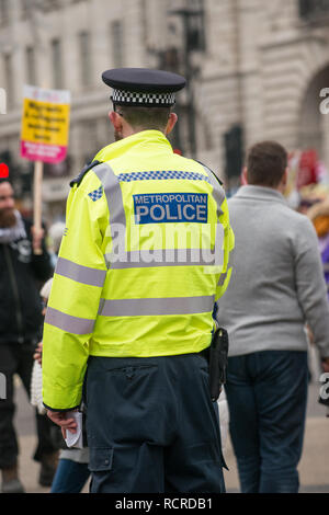 Metropolitan Police signe sur le dos d'une veste haute visibilité portés par des agents de police escortent une manifestation de rue à travers le centre de Londres, au Royaume-Uni. Banque D'Images