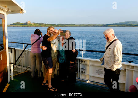 La famille et les amis prendre photographie selfies sur des ferry entre Oban et Craignure Mull Banque D'Images