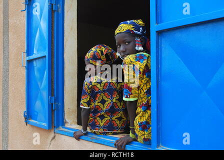 Deux jeunes filles Peuls s'asseoir dans la fenêtre ouverte d'une salle de classe en milieu rural au Niger, Afrique Banque D'Images