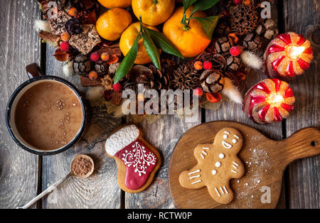 Gingerbread cookies faits maison de Noël, du chocolat chaud et des bougies sur table en bois Banque D'Images