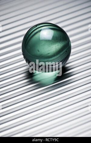 Bille de verre sur une table métallique. Banque D'Images