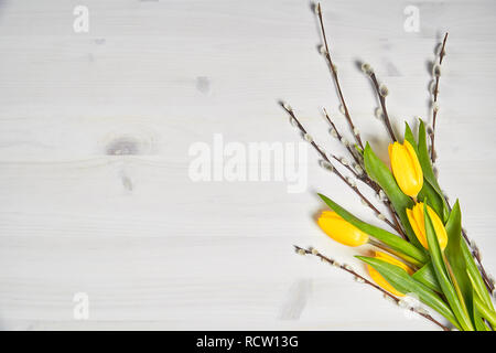 Belle décoration de pâques de tulipes jaunes et blanches sur un chatons de table en bois Banque D'Images