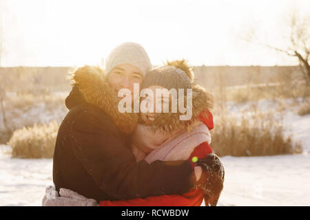 Épris d'adolescents à ce jour en hiver. Guy et petite amie s'embrassent et sourire. La joie d'être ensemble. Premier amour. Concept pour la Saint-Valentin. Banque D'Images