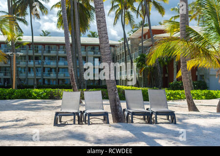 Bâtiments et des chaises au milieu des palmiers dans la station balnéaire de Punta Cana. Banque D'Images