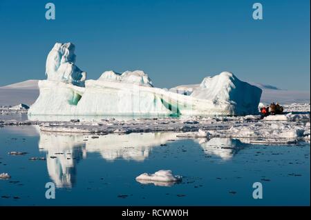 Zodiaque avec les touristes en croisière dans l'avant d'un iceberg, mer de Weddell, l'Antarctique Banque D'Images