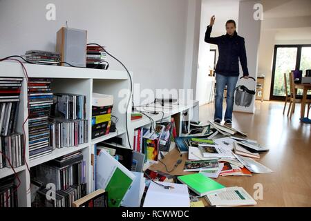 Jeune femme à la découverte des lieux d'un cambriolage, l'étagère à sac Banque D'Images