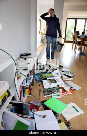 Jeune femme à la découverte des lieux d'un cambriolage, l'étagère à sac Banque D'Images