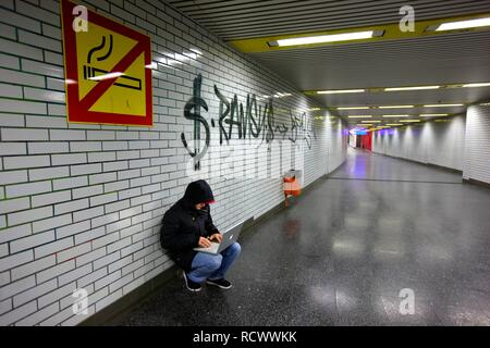 Pirate surf sur un ordinateur portable dans un passage du métro, image symbolique pour le piratage informatique, la criminalité informatique, la cybercriminalité Banque D'Images