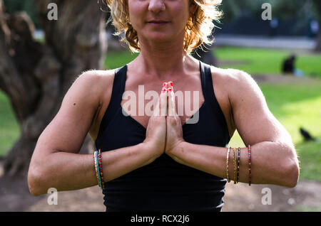 Belle jeune femme médite en yoga asana Padmasana - Lotus poser sur la terrasse en bois dans le parc de l'automne. Banque D'Images