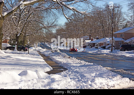 Une route de quartier après une forte tempête dans la région de Falls Church, Virginie, USA. Couche de neige sur les branches d'arbres après la tempête. Banque D'Images