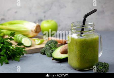 Green smoothies en bocal verre mason avec des légumes frais et des herbes : brocoli, avocat, citron vert, céleri, pomme, kiwi, le persil. detox smoothies Banque D'Images