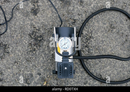 Gonfleur de pneu de voiture sur la route de l'outil. Metal Portable pompe du compresseur d'air pour les roues de voiture, équipement pilote Banque D'Images