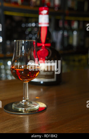 Verre et la bouteille de liqueur de Grand Marnier sur le comptoir du bar. Banque D'Images