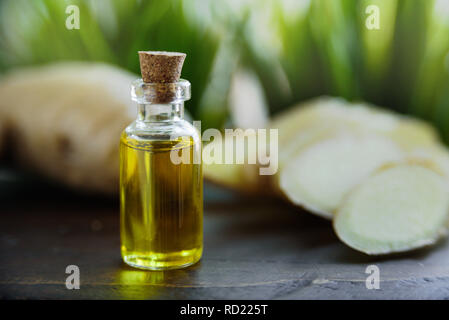 Bouteille d'huile de gingembre. La racine de gingembre sur l'arrière-plan, les feuilles vert Banque D'Images