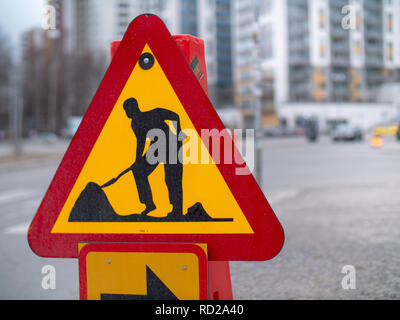 Le rouge et jaune travaux signe avec détour flèche sur une rue à Stockholm Banque D'Images