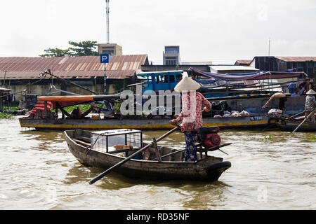 Femme vendant pains d'un petit bateau traditionnel dans le marché flottant sur la rivière Hau. Can Tho, Delta du Mékong, Vietnam, Asie Banque D'Images