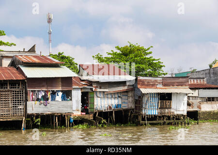 Cabane en tôle vietnamien typique des maisons sur pilotis au bord de la rivière Hau. Can Tho, Delta du Mékong, Vietnam, Asie Banque D'Images