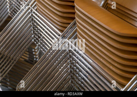 Chaises empilées avec sièges en bois et métalliques jambes Banque D'Images
