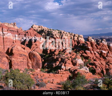 USA, Utah, Arches National Park, fournaise ardente salon avec palmes composé de brown Entrada Sandstone sous une couche de grès Navajo plus léger. Banque D'Images