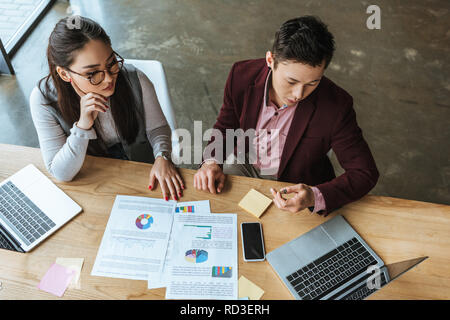 Portrait de jeunes gens d'affaires kazakh travaillant avec des ordinateurs portables et des documents dans Office Banque D'Images