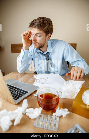 Se sentir malade et fatigué. L'homme avec une tasse de thé chaud working in office, homme d'affaires pris froid, la grippe saisonnière. La pandémie de grippe, la prévention des maladies, la climatisation au pouvoir provoquer la maladie Banque D'Images