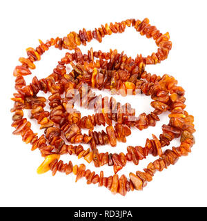 Chaîne de perles d'ambre baltique isolé sur fond blanc. Collier ambre orange vif de matières perles en un tas. Banque D'Images