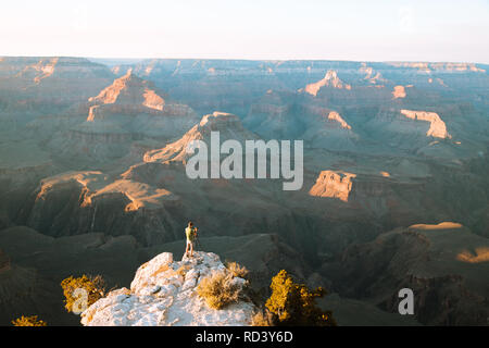 Un photographe est debout sur une falaise en profitant de la magnifique vue sur la célèbre Grand Canyon National Park au coucher du soleil, sud-ouest américain, USA Banque D'Images