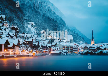 Vue panoramique de célèbre ville au bord du lac de Hallstatt dans les Alpes en mystic blue hour pendant le crépuscule à l'aube sur un beau jour brumeux froid en hiver, Salzk Banque D'Images