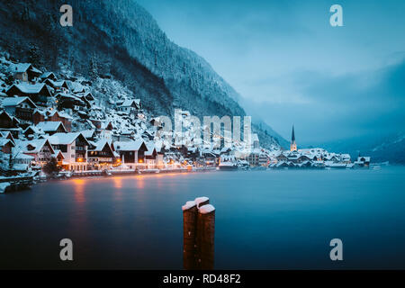 Vue panoramique de célèbre ville au bord du lac de Hallstatt dans les Alpes en mystic blue hour pendant le crépuscule à l'aube sur un beau jour brumeux froid en hiver, Salzk Banque D'Images