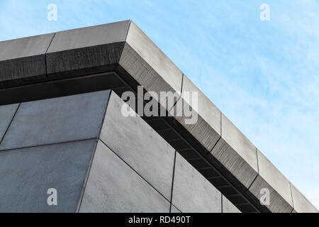 Résumé L'architecture contemporaine en pierre grise, fragment d'angle d'un bâtiment industriel under blue sky Banque D'Images