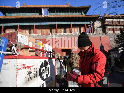 (190117) -- BEIJING, le 17 janvier 2019 (Xinhua) -- Yang Hongyi offre des forfaits à l'extérieur d'une porte de la Cité Interdite à Beijing, capitale de la Chine, 15 janvier 2019. En près de trois années de travail en tant que livreur dans le voisinage de la Cité Interdite, 44-year-old Yang Hongyi a livré plus de 100 000 paquets sans même un seul commentaire négatif de ses clients. Yang travaille de l'aube à la nuit tous les jours, au cours desquels il a besoin pour fournir environ 200 paquets et faire environ 200 appels de clients. Comme la fête du printemps approche, Yang a à offrir un supplément de 100 colis par jour. De nombreux clients Banque D'Images