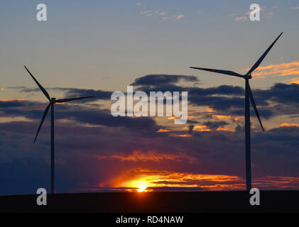 Sieversdorf, Allemagne. 17 Jan, 2019. Le soleil se couche derrière les nuages sombres au-dessus d'un champ avec deux éoliennes. Crédit : Patrick Pleul/dpa-Zentralbild/dpa/Alamy Live News Banque D'Images