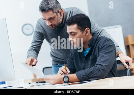 Des collègues de travail concentré sur le lieu de travail les documents de discussion Banque D'Images