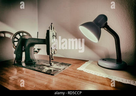 Lampe et vieille machine à coudre sur la table de travail Banque D'Images