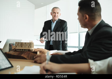 Montrant l'architecte bâtiment miniature à Réunion d'affaires avec client Banque D'Images