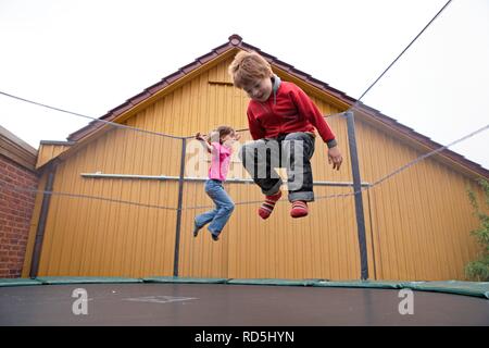 Les enfants de rebondir sur un trampoline Banque D'Images