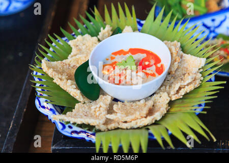 Craquelins de riz croustillant aux herbes avec trempette de haricots de soja préservé mijotés au lait de coco servi sur des feuilles de bananier dans un restaurant thaïlandais. Thaïlande Banque D'Images