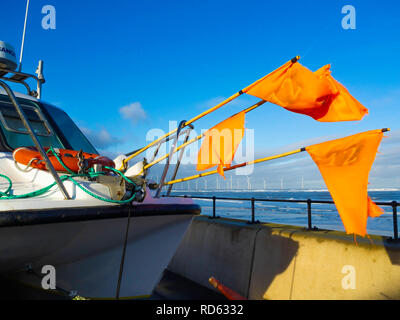 Un petit bateau de pêche en stationnement sur l'Esplanade de Redcar North Yorkshire England UK avec drapeaux orange vif sur des bouées de casiers à crabe ou homard Banque D'Images