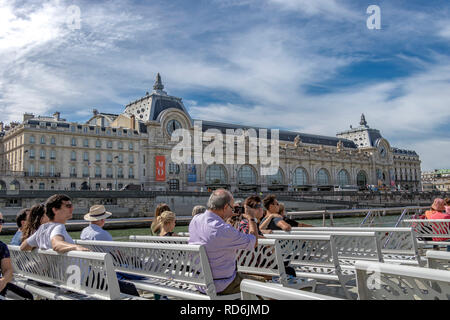 Les touristes et les visiteurs à bord d'un fleuve la Seine Bateaux Mouches Croisière touristique , passer par le Musée d'Orsay sur une chaude journée d'été à Paris Banque D'Images