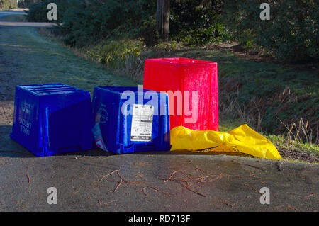 Vide la tête en bas des bacs de recyclage de la boîte bleue en bordure avec un casier rouge pour les matières plastiques et d'un sac jaune pour le carton. Banque D'Images