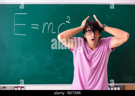 Jeune homme physic debout devant le conseil vert Banque D'Images