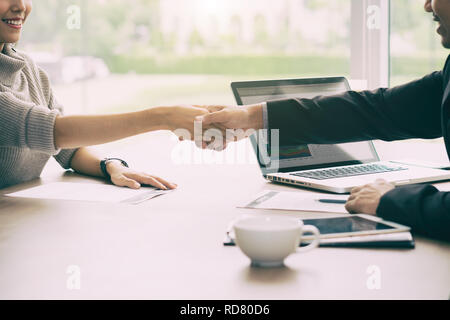 Entretien d'Asian businessman and businesswoman shaking hands in lors de l'achèvement d'une réunion. Banque D'Images