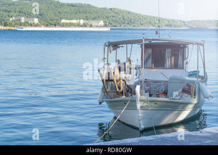 Petit bateau de pêche surchargé blanc à côté du quai. Banque D'Images