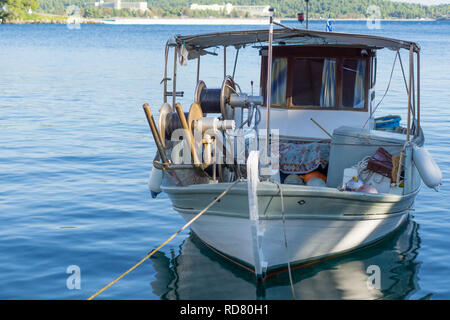 Petit bateau de pêche surchargé blanc à côté du quai. Banque D'Images